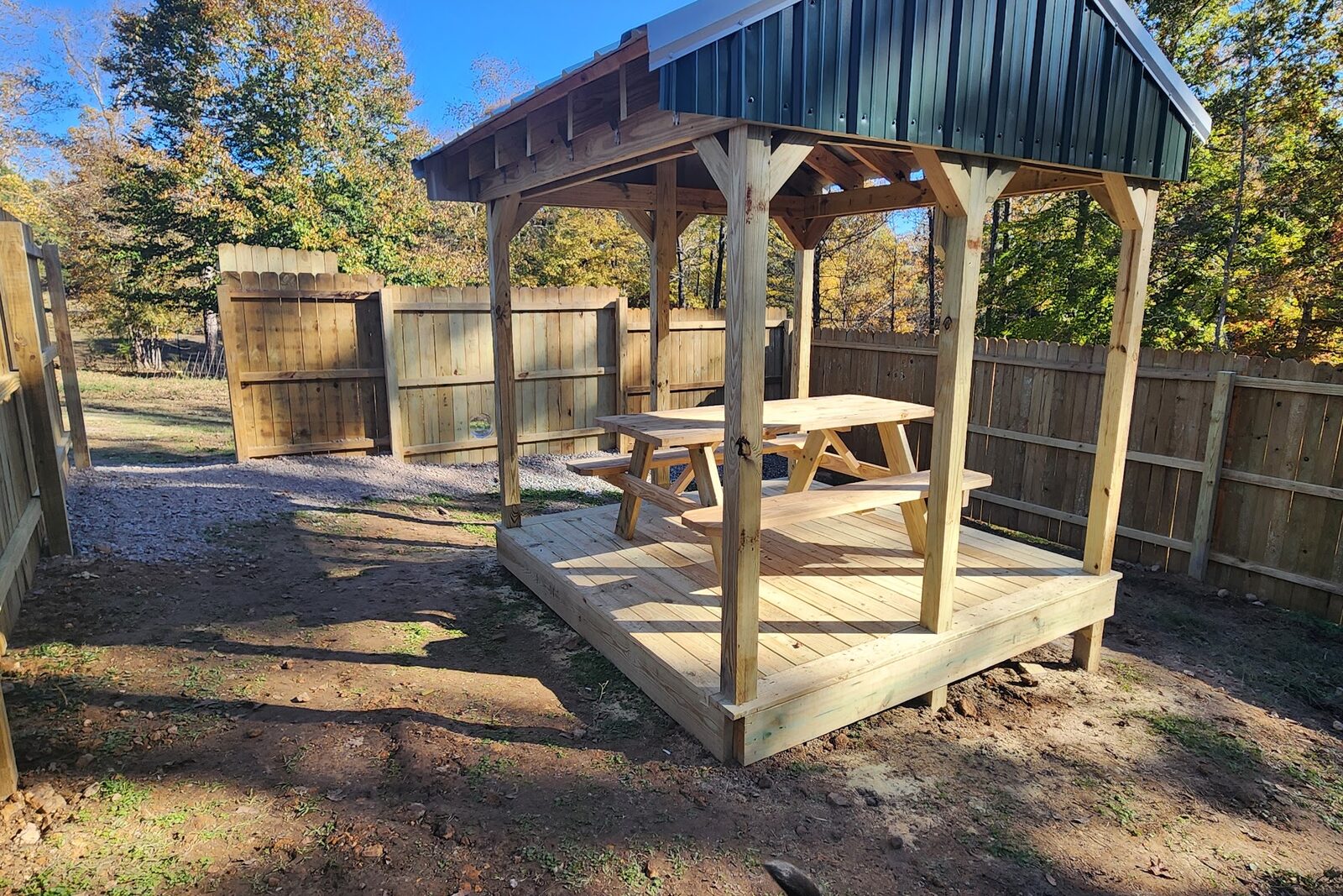 The shaded pavilion in the fenced play yard at Dogtown Kennels